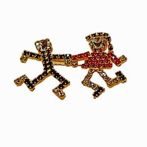 Rhinestone dancers brooch. Red/black/clear on gold tone.